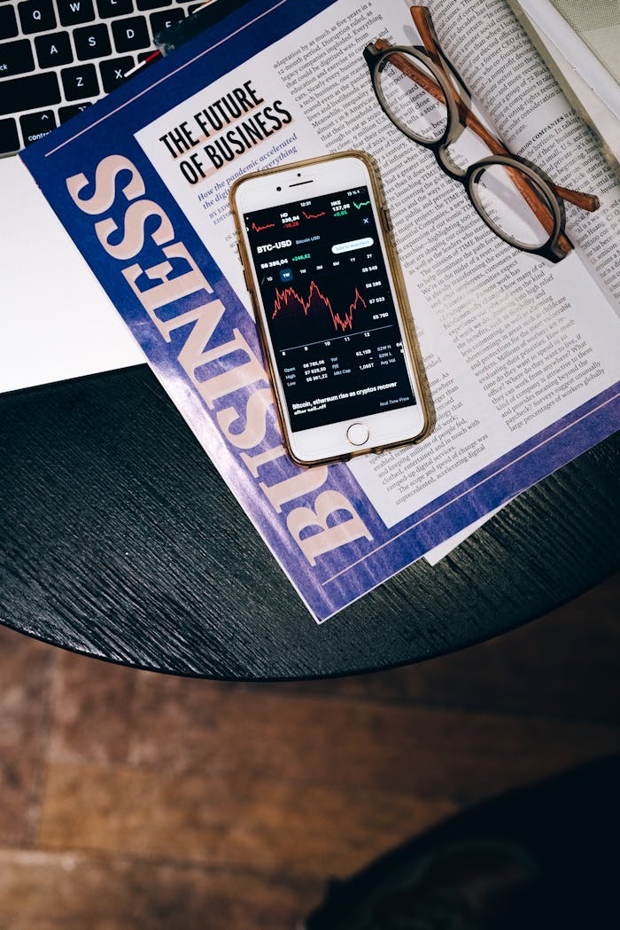 Smartphone displaying stock data on a magazine titled 'The Future of Business'.